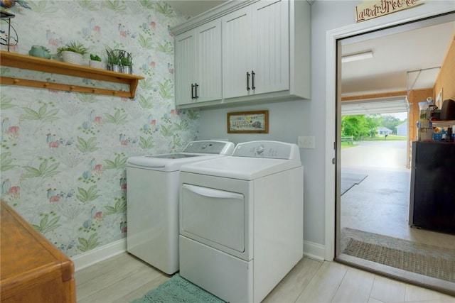 washroom featuring baseboards, independent washer and dryer, cabinet space, and wallpapered walls