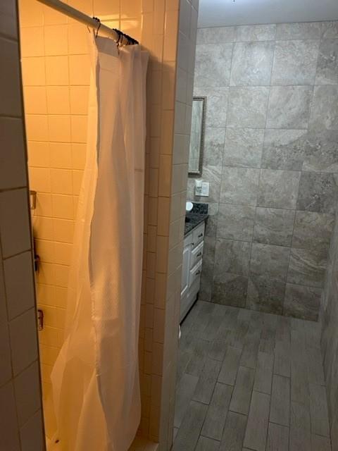 bathroom with walk in shower and tile walls