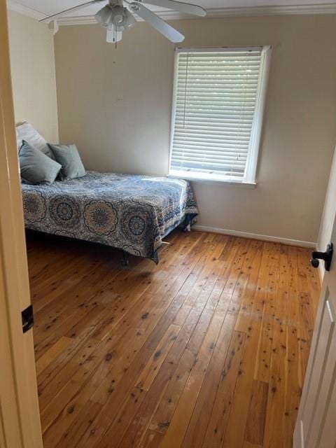 bedroom with ceiling fan, crown molding, and light hardwood / wood-style flooring