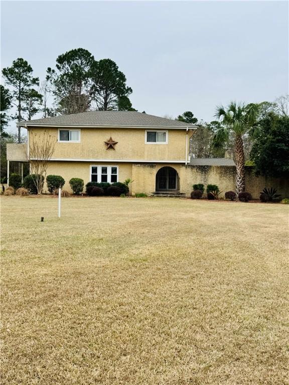 back of property featuring a yard