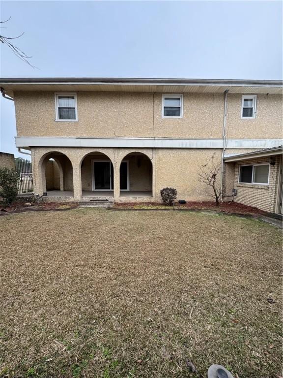 back of property featuring a lawn