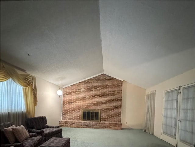 unfurnished living room with vaulted ceiling, brick wall, carpet flooring, a brick fireplace, and a textured ceiling