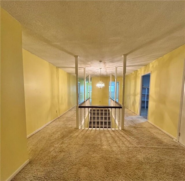 basement featuring an inviting chandelier, carpet floors, and a textured ceiling