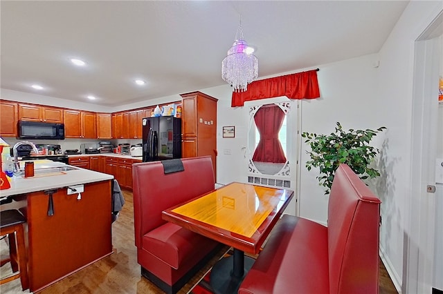 4718 Otter Creek Cir, Blackshear, GA 31516 - kitchen with black appliances, light wood-type flooring, brown cabinetry, light countertops, and a peninsula