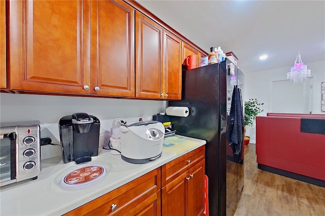 4718 Otter Creek Cir, Blackshear, GA 31516 - kitchen featuring light wood-style floors, light countertops, brown cabinetry, freestanding refrigerator, and recessed lighting