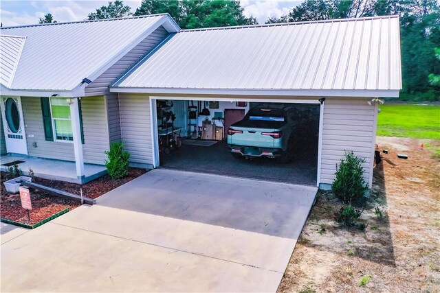 4718 Otter Creek Cir, Blackshear, GA 31516 - view of front facade with driveway, a metal roof, a garage, and a porch
