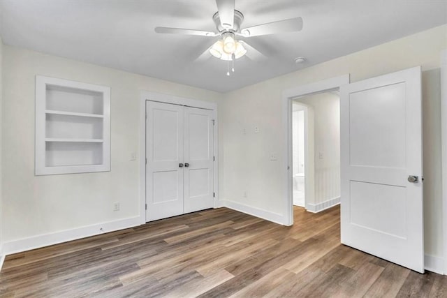 unfurnished bedroom with ceiling fan, wood-type flooring, and a closet