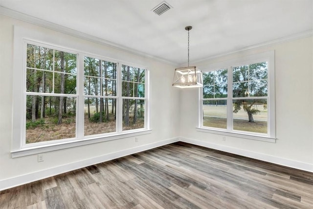 unfurnished dining area with ornamental molding and hardwood / wood-style floors