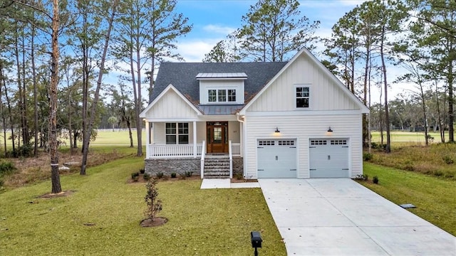 view of front of house featuring a porch, a garage, and a front lawn