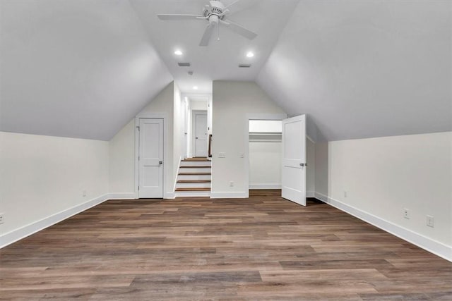 additional living space with ceiling fan, dark hardwood / wood-style flooring, and vaulted ceiling