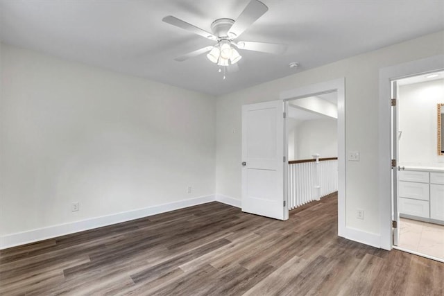 unfurnished bedroom featuring dark wood-type flooring, ceiling fan, and ensuite bathroom