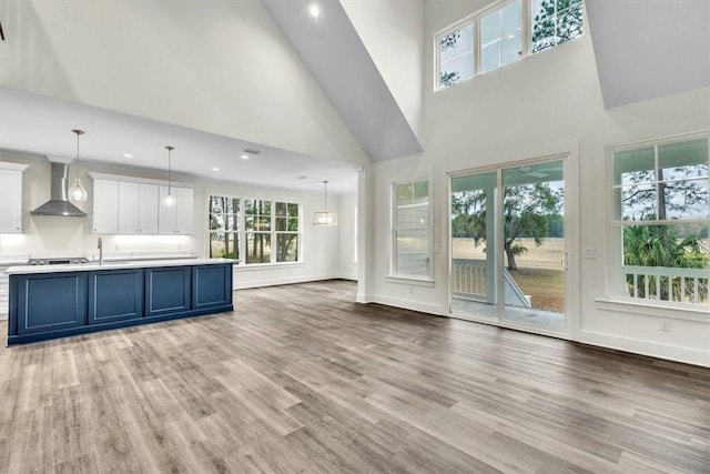 unfurnished living room with sink, hardwood / wood-style floors, and a high ceiling