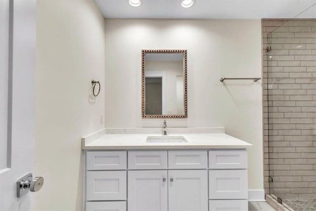 bathroom featuring a shower with door and vanity