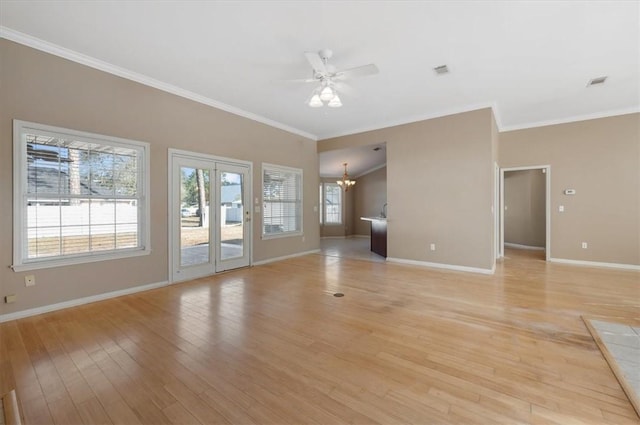 unfurnished living room with ceiling fan with notable chandelier, ornamental molding, and light wood-type flooring