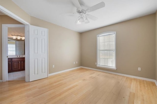 empty room with ceiling fan, light hardwood / wood-style flooring, and a healthy amount of sunlight