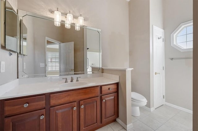 bathroom with toilet, vanity, and tile patterned floors