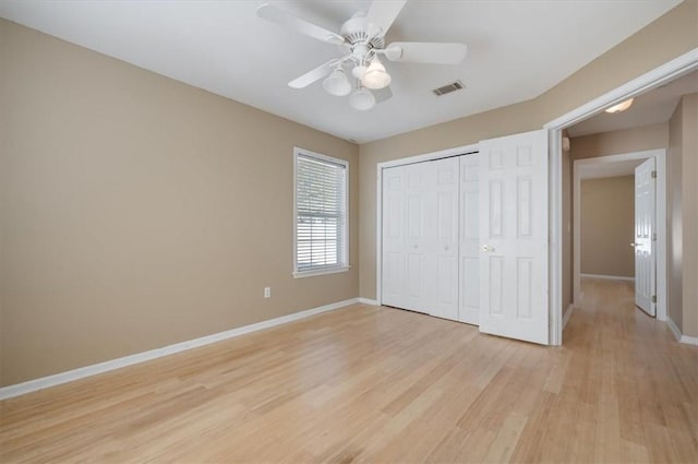 unfurnished bedroom featuring ceiling fan, a closet, and light hardwood / wood-style flooring