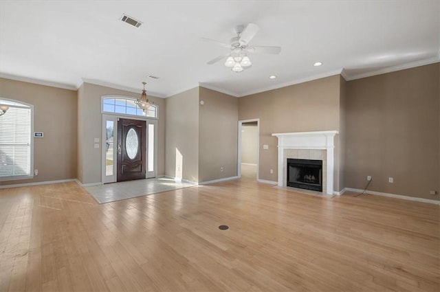 entrance foyer featuring light hardwood / wood-style floors, ornamental molding, ceiling fan, and a fireplace