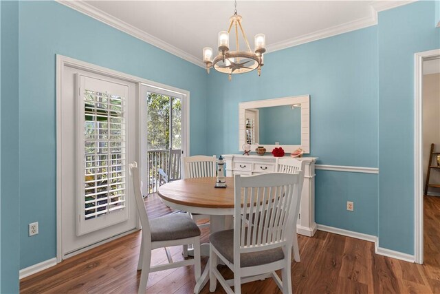 dining area with a chandelier, dark hardwood / wood-style flooring, and crown molding