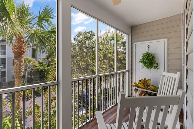 unfurnished sunroom with ceiling fan