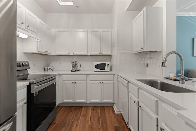 kitchen featuring decorative backsplash, stainless steel appliances, sink, white cabinets, and dark hardwood / wood-style floors