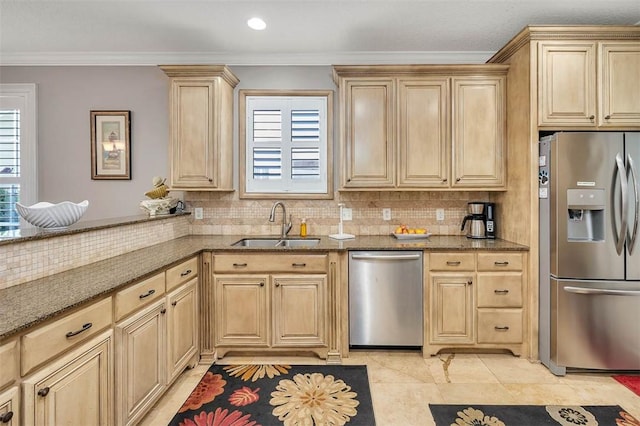 kitchen with appliances with stainless steel finishes, crown molding, sink, light brown cabinets, and dark stone countertops