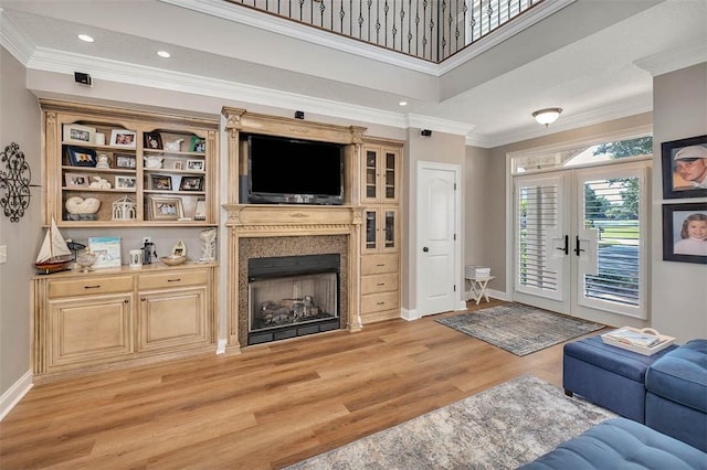 living room featuring crown molding, light hardwood / wood-style flooring, and french doors