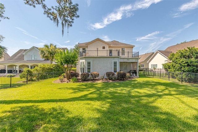 back of property featuring a balcony and a yard