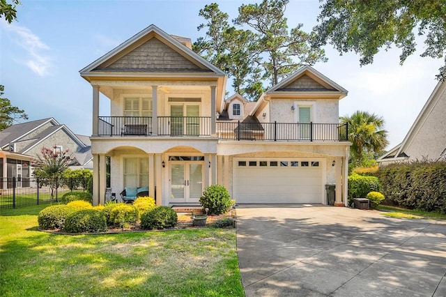 view of front of property with a garage, french doors, a balcony, and a front lawn