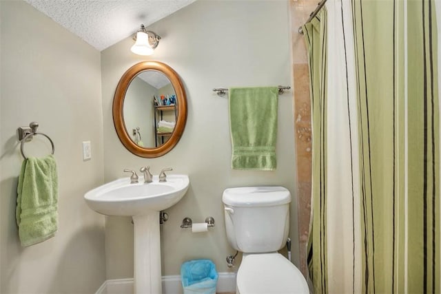 bathroom featuring lofted ceiling, sink, a shower with shower curtain, toilet, and a textured ceiling