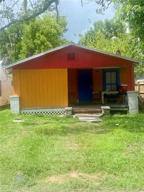 view of outdoor structure with covered porch and a yard