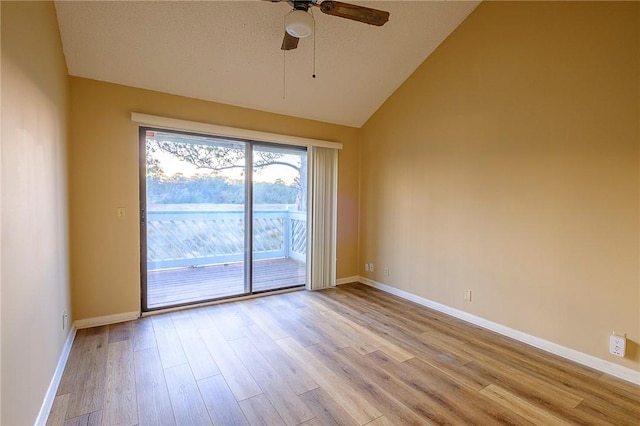 empty room with a textured ceiling, high vaulted ceiling, light hardwood / wood-style flooring, and ceiling fan