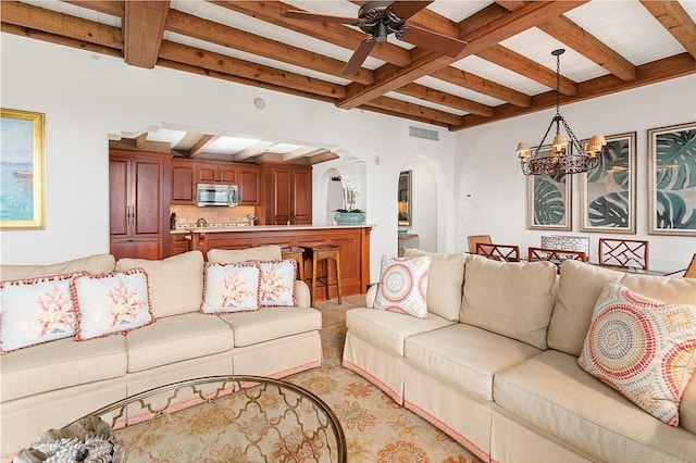 living room featuring ceiling fan with notable chandelier and beam ceiling