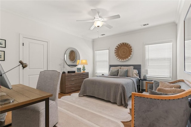 bedroom with ceiling fan, visible vents, and crown molding