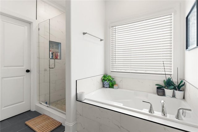 bathroom with a shower stall, a bath, and tile patterned floors