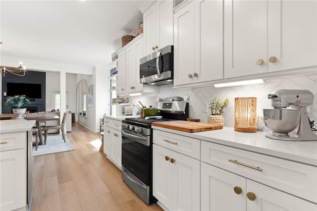 kitchen featuring light countertops, appliances with stainless steel finishes, backsplash, and white cabinetry