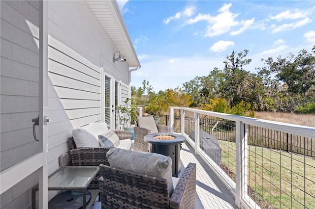 balcony featuring an outdoor living space with a fire pit