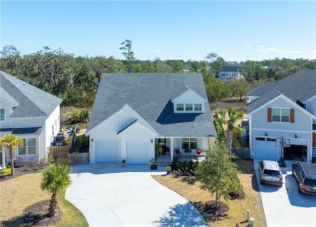 view of front of home featuring an attached garage, a shingled roof, fence, and concrete driveway