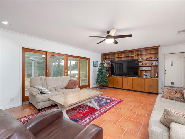 living room featuring crown molding, tile patterned flooring, ceiling fan, and a brick fireplace