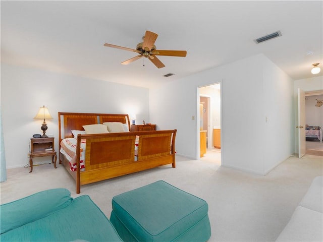 carpeted bedroom with ensuite bathroom and ceiling fan