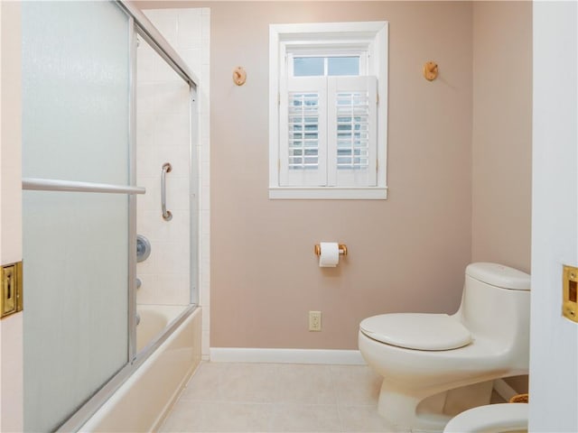 bathroom with shower / bath combination with glass door, tile patterned floors, and toilet