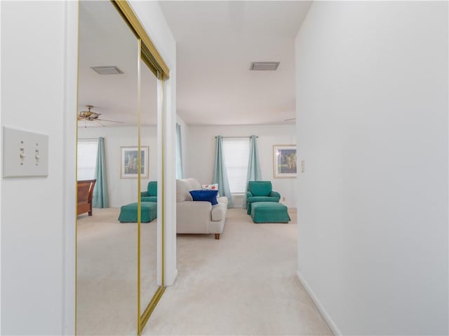 corridor with light carpet and a wealth of natural light