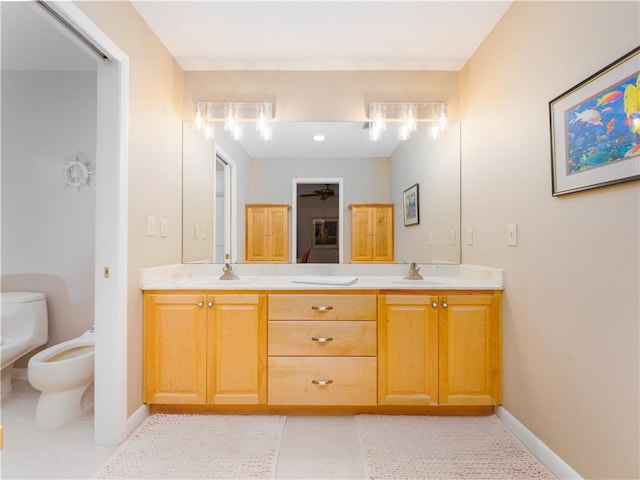 bathroom featuring toilet, vanity, tile patterned floors, and a bidet