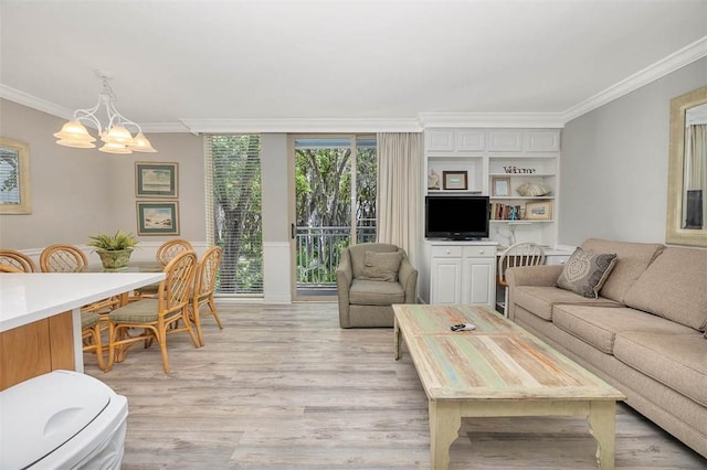 living room with crown molding, light wood-style floors, and a notable chandelier