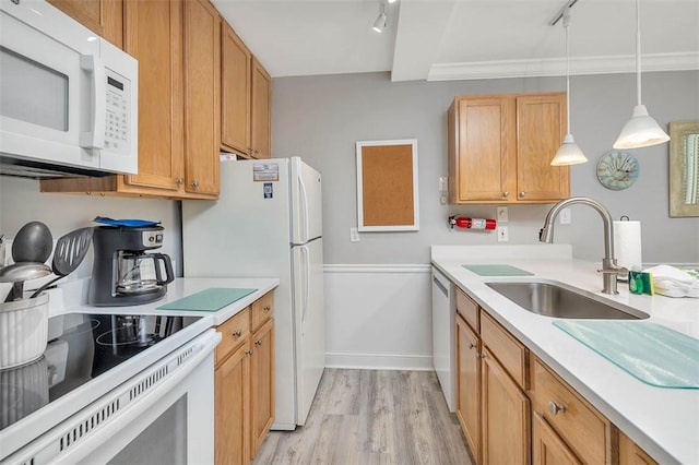 kitchen featuring track lighting, white appliances, light countertops, a sink, and light wood-style flooring