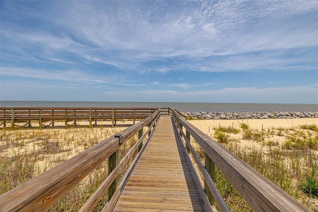 view of property's community with a water view and a beach view