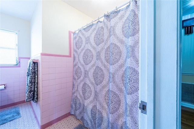 177 Pinewood St, Folkston, GA 31537 - bathroom featuring tile walls, a wainscoted wall, tile patterned floors, and curtained shower