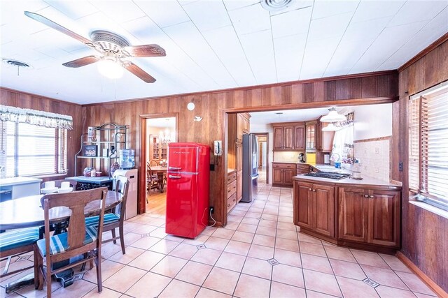 177 Pinewood St, Folkston, GA 31537 - kitchen featuring appliances with stainless steel finishes, wood walls, healthy amount of natural light, ceiling fan, and brown cabinets