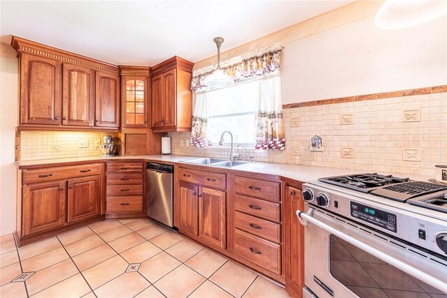 177 Pinewood St, Folkston, GA 31537 - kitchen with stainless steel appliances, light countertops, brown cabinetry, light tile patterned flooring, and glass insert cabinets