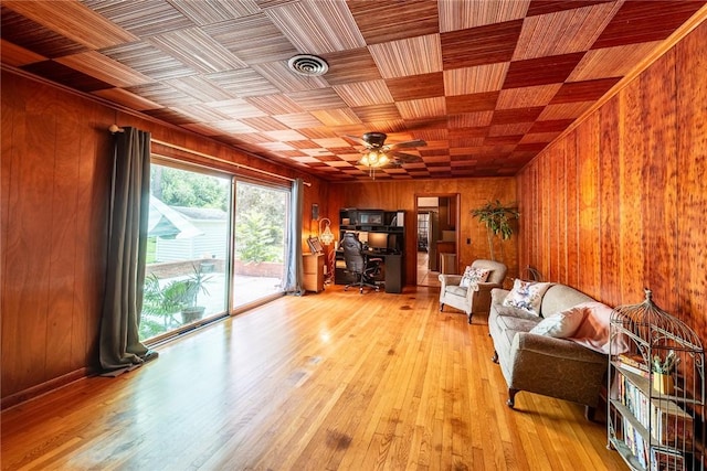 177 Pinewood St, Folkston, GA 31537 - living room with wooden walls, a desk, a ceiling fan, and light wood-style flooring